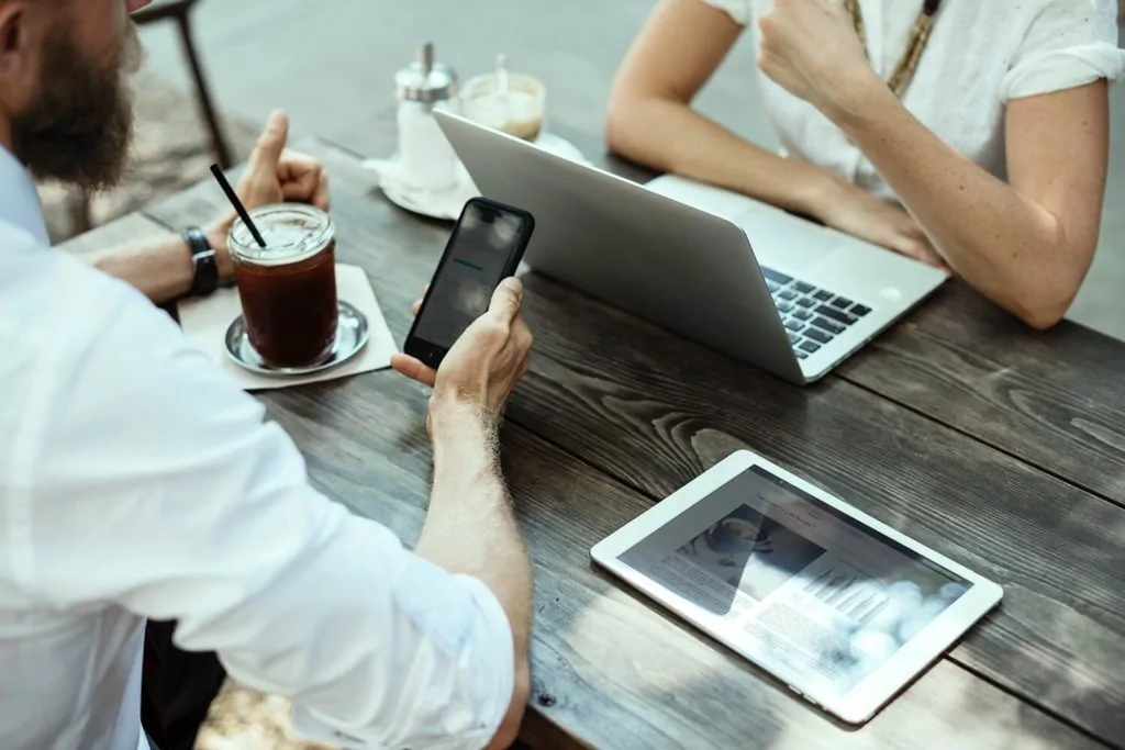 People working on computer and tablet with coffee