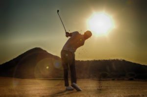 A golfer takes his shot into the late afternoon sun at Euphoria Golf course in Limpopo South Africa.
