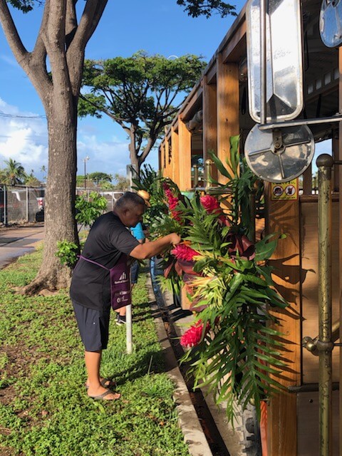 Polynesian Connection members placing flowers around trolly