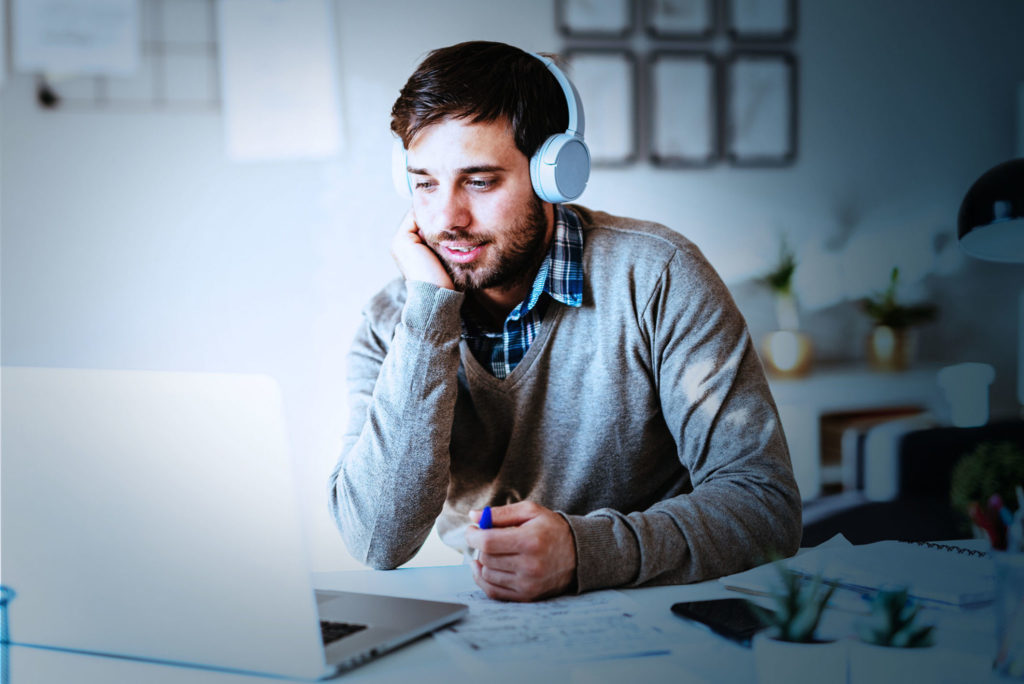 man on computer wearing headphones