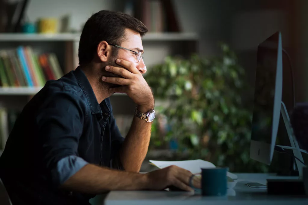 Man looking at computer. Centralized logging helps identify problems on your network.